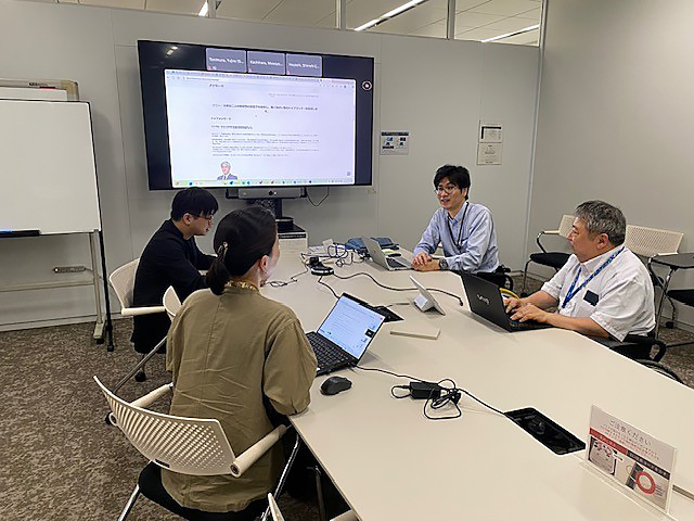 4名の社員が東京オフィスで会議を行っている社員の様子