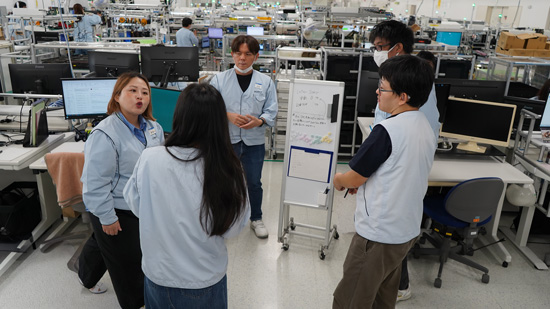 社員4名が立ったまま朝のミーティングをしている様子