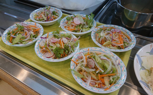 収穫された野菜が食堂でサラダとして提供されている