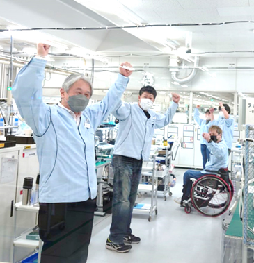 製造エリアで社員5名がラジオ体操をしている