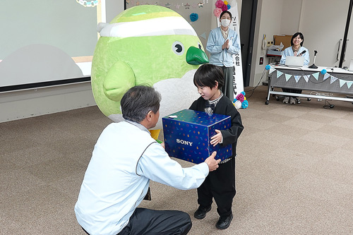 男の子が代表取締役社長からランドセルを受け取っている様子